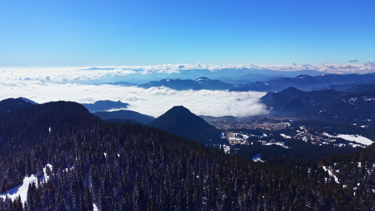Vista Aérea de Montanhas de Inverno com Nuvens Cobrindo uma Cidade no Vale