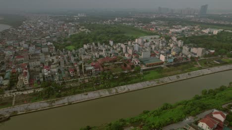 Aerial-pan-shot-of-Hanoi-cityscape-situated-beside-a-lake-in-Vietnam