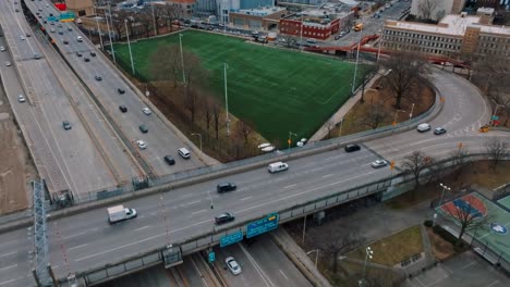 4K-Drohne-Fliegt-über-Autobahn-Und-Fußballplatz-In-Harlem,-New-York-City,-Tag