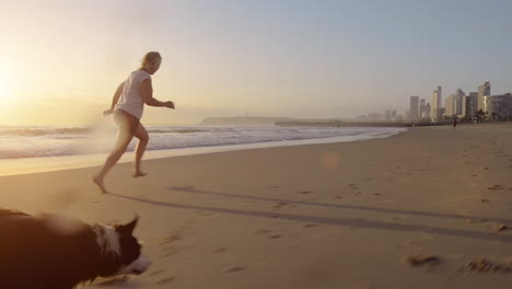 Woman-running-dog-on-beach-lifestyle-steadicam-shot