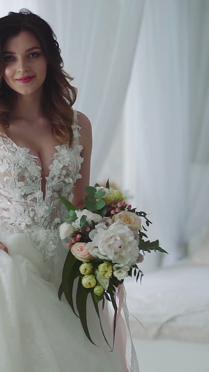 Beautiful young bride in bedroom. Beautiful young bride in white wedding dress indoors Vertical video