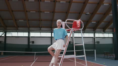 woman posing on tennis court ladder