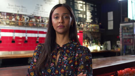 portrait of female bar owner standing by counter