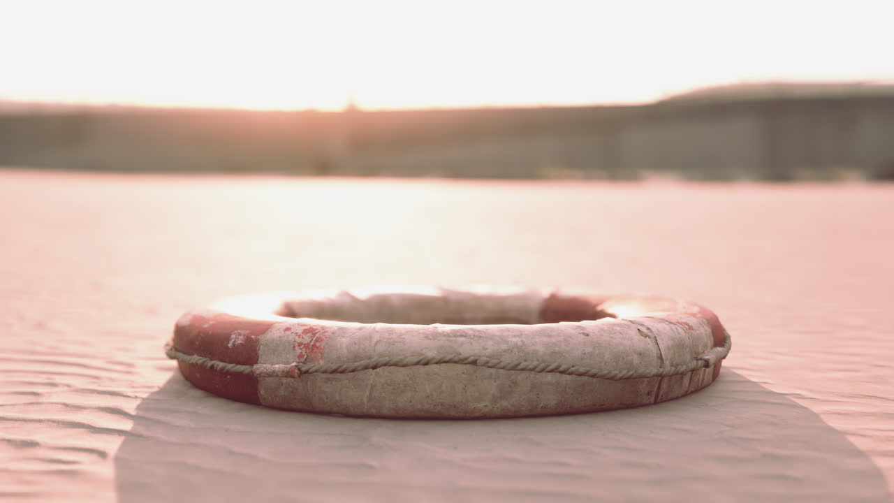 해가 지는 모래 해변 에 있는 은 구명선