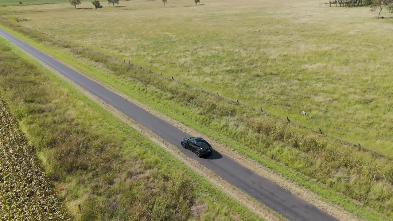 Un'auto viaggia lentamente attraverso la campagna agricola