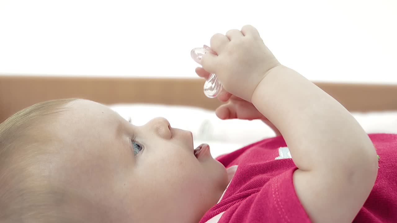 el bebé juega con un chupete