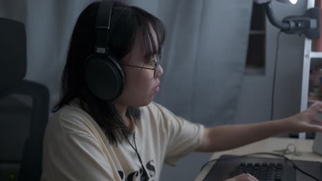 Woman-wears-headset-and-glasses,-works-at-computer-typing-on-keyboard