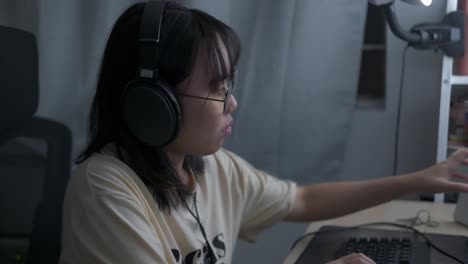 woman wears headset and glasses, works at computer typing on keyboard