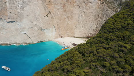 navagio beach with boats and tourists - popular shipwreck beach in zakynthos, ionian islands of greece