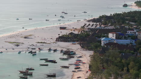 panorama of zanzibar beach with a lot of people and boats in the water