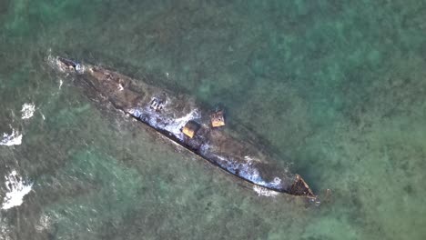 Drone-aerial-over-the-top-of-Mildura-shipwreck-showing-waves-crashing-into-it-while-in-beautiful-water