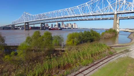 rising shot of the crescent city bridge over the mississippi river reveals the new orleans louisiana skyline