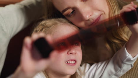 Un-Niño-Sonriente-Sostiene-Una-Película-Mirando-Fotografías-Con-Sus-Padres.