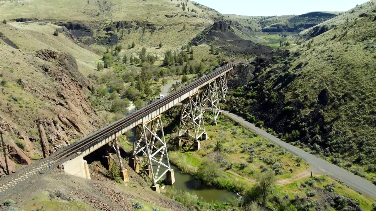 US, Oregon, Madras, Trout Creek, 2025-04-19 - Drone view of a steel train trestle bridge over the creek in the springtime in central Oregon.