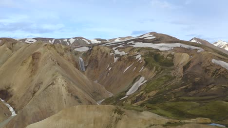 Flying-a-drone-into-the-colourful-rhyolite-mountains-of-the-highlands-in-Iceland-up-to-a-waterfall