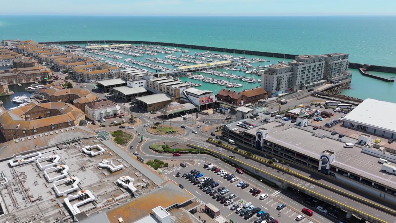 Brighton Marinan satamalaitos ja urbaani rannikkoympäristö vähittäiskaupan pysäköintialueineen Etelä-Englannissa