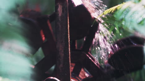 spinning wooden garden water wheel pushed by strong falling stream