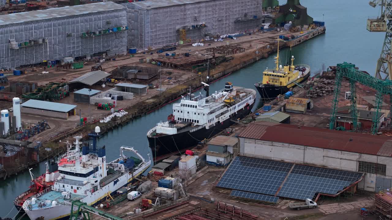 Ships passing through the Gdansk Shipyard in Poland with warehouses and solar panels