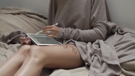 woman using tablet on bed