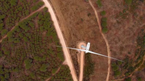 aerial shot flying over a wind turbine in barao de sao joao, portugal.