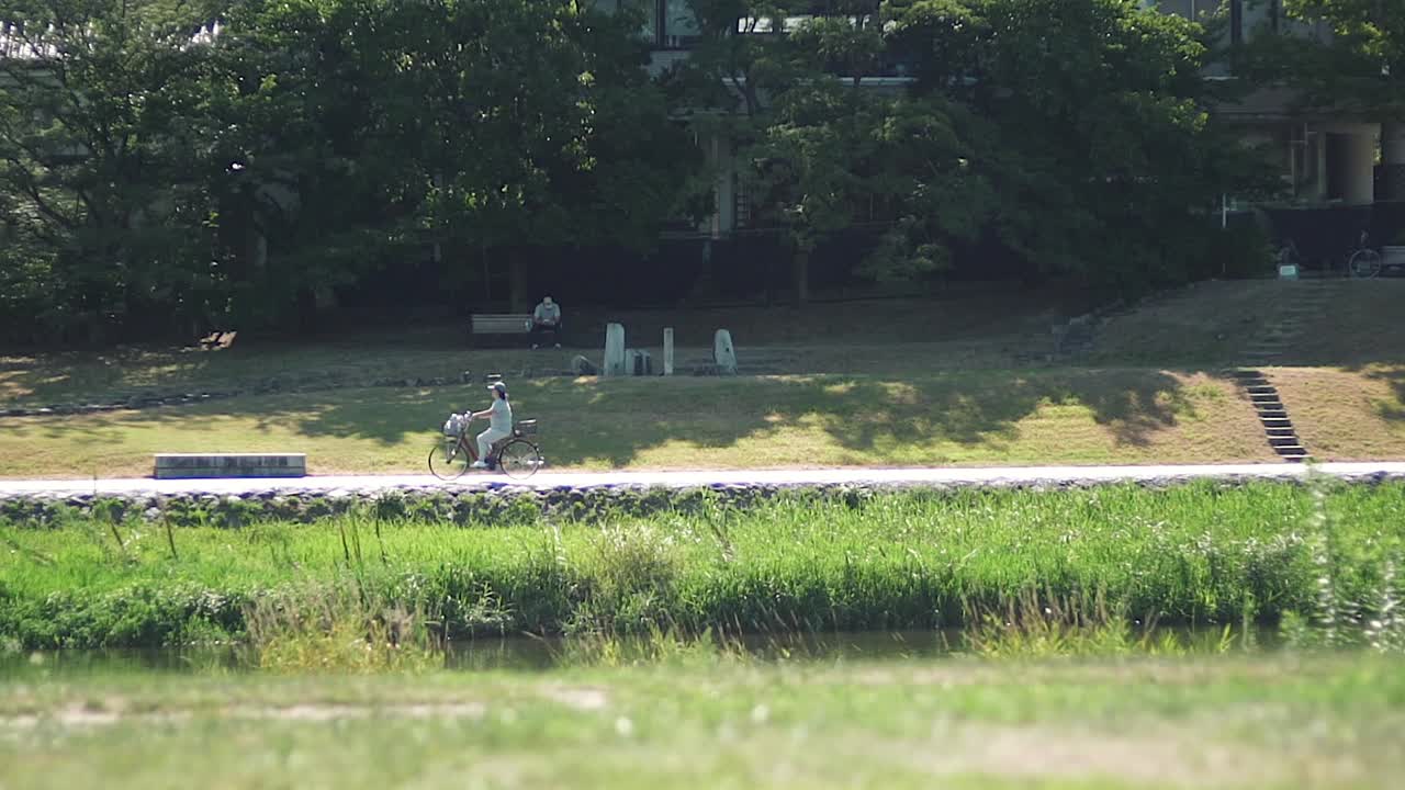 일본 교토에서 밝고 화창한 날 자전거를 타는 모자를 쓴 여성