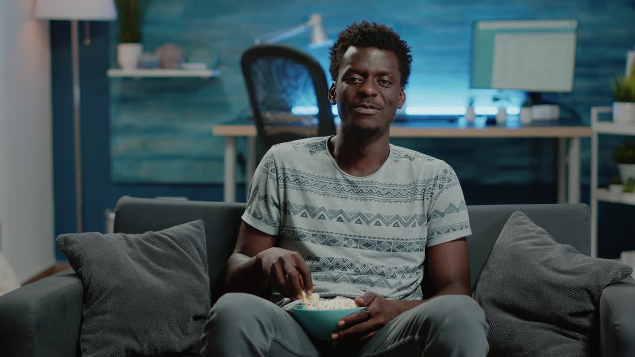 POV of adult watching comedy on television with popcorn