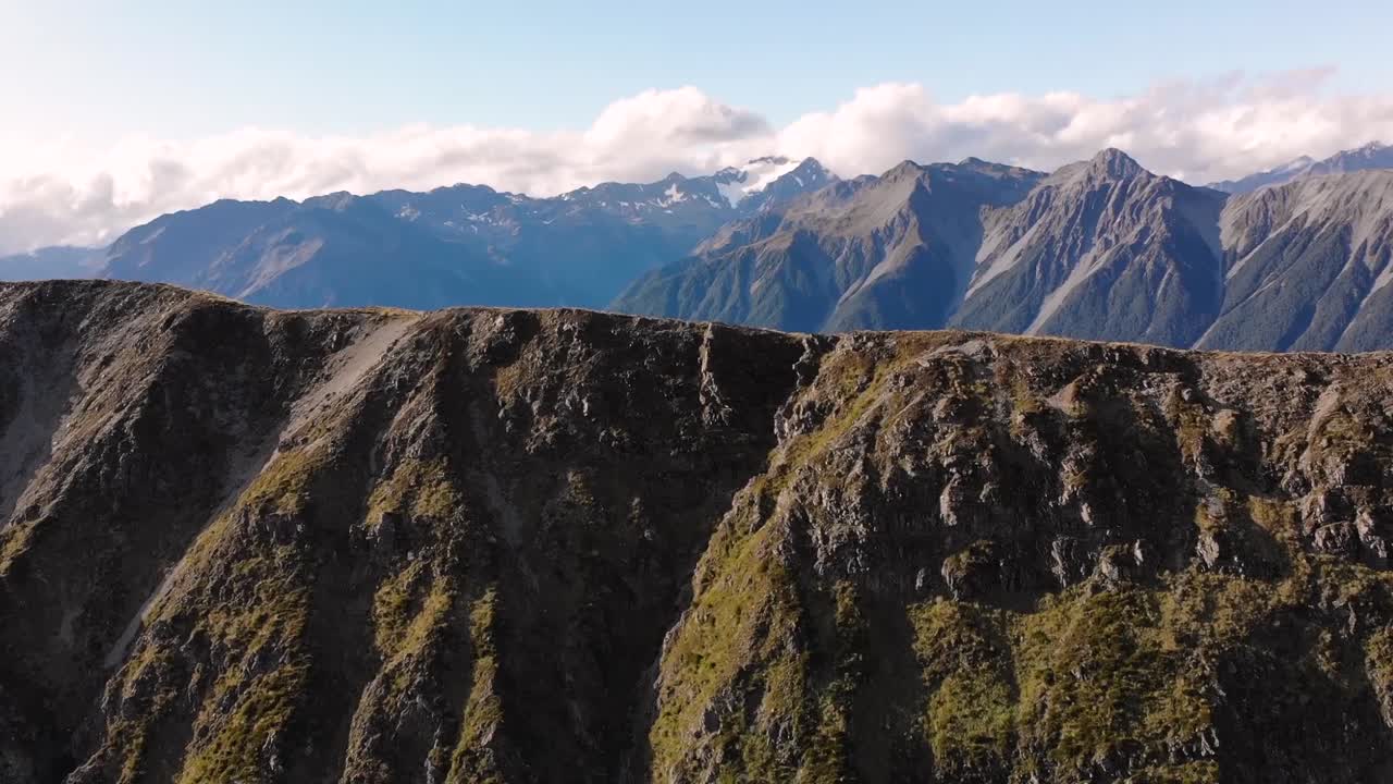 Scenery of Southern Alps, Arthurs Pass aerial birds eye shot fly over mountain ridge, valley and mountains reveal. New Zealand