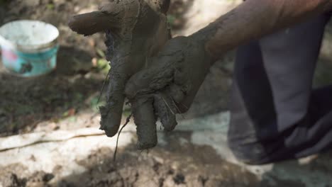 Dirty-hands-close-up-shot---a-man-clean-his-hands-from-wet-clay