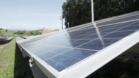 Close-up-dolly-pull-out-of-a-poly-crystalline-solar-photovoltaic-module-from-a-large-solar-farm-on-a-hill-near-forests-in-nature-on-a-beautiful-clear-sky-day