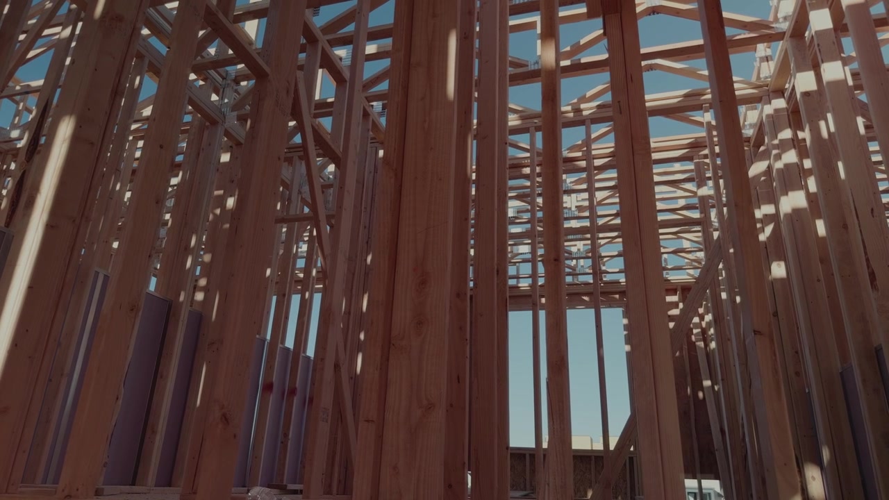 Slow rotating pan from floor to ceiling through wooden framing structure.