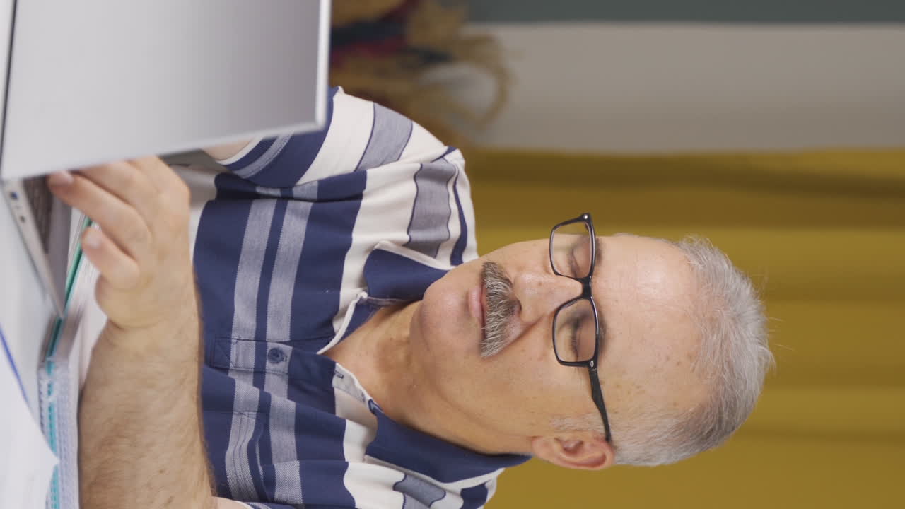 video vertical de un anciano trabajador de la oficina en casa asistiendo a una reunión de negocios en línea.