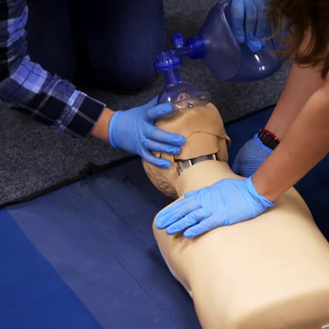 dummies for medics used for first aid trainings. oxigen masks near medical dolls. two medics train on courses