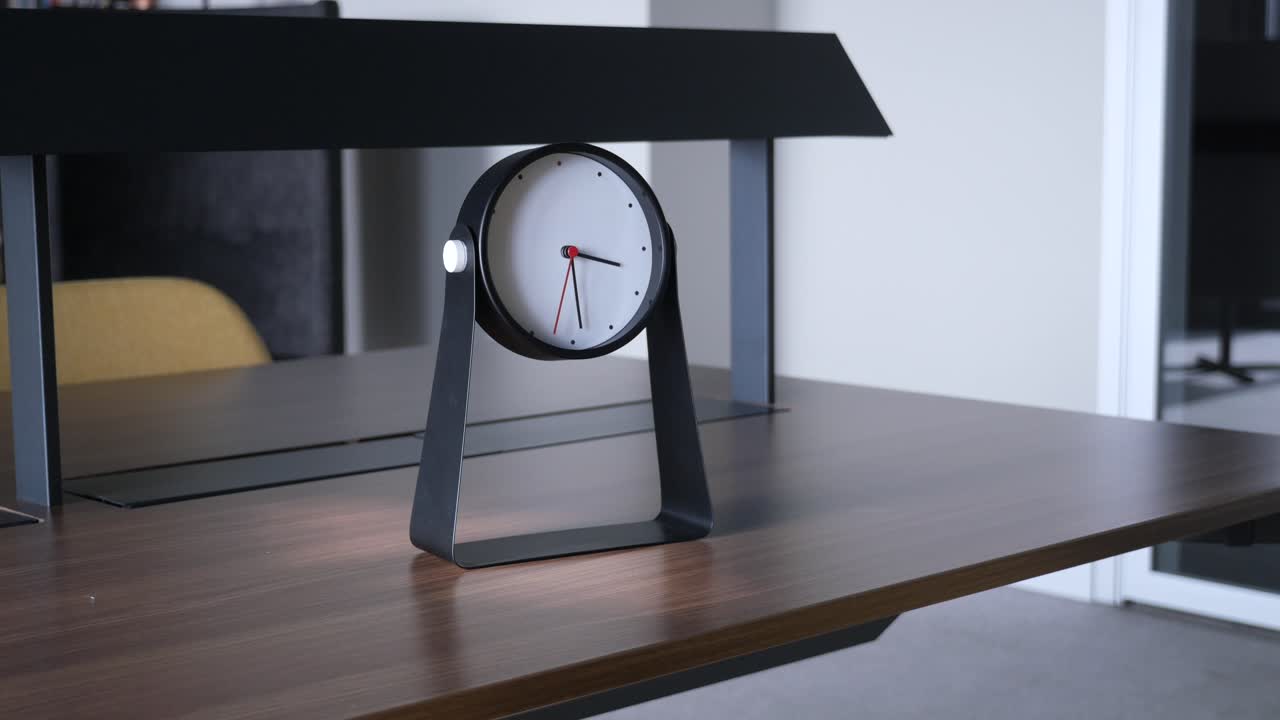 나무 테이블 위 에 있는 현대적 인 검은색 책상 시계