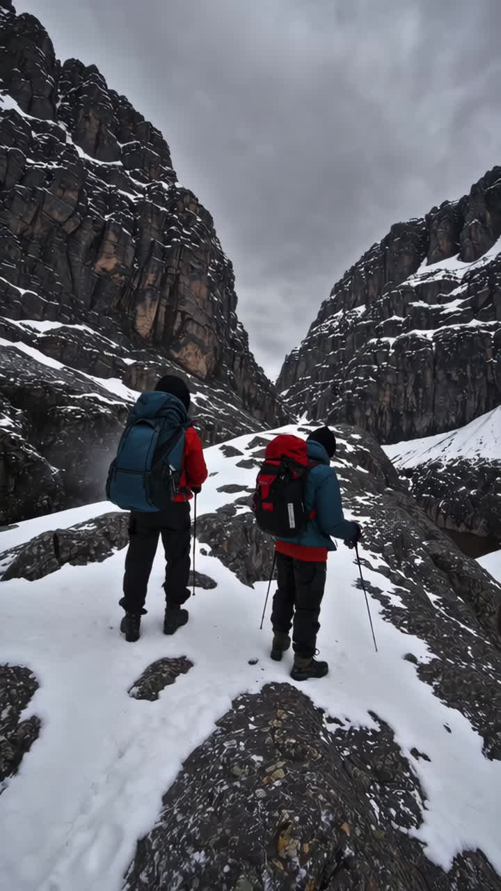 Two Hikers Navigating a Snowy Mountain Pass
