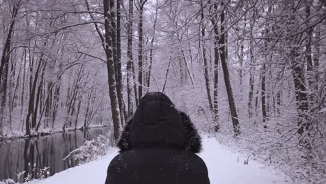 person in black boat in beautiful snowy nature scenery in poland forest