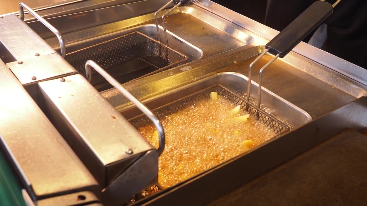 French Fries Frying in Hot Oil in a Commercial Deep Fryer