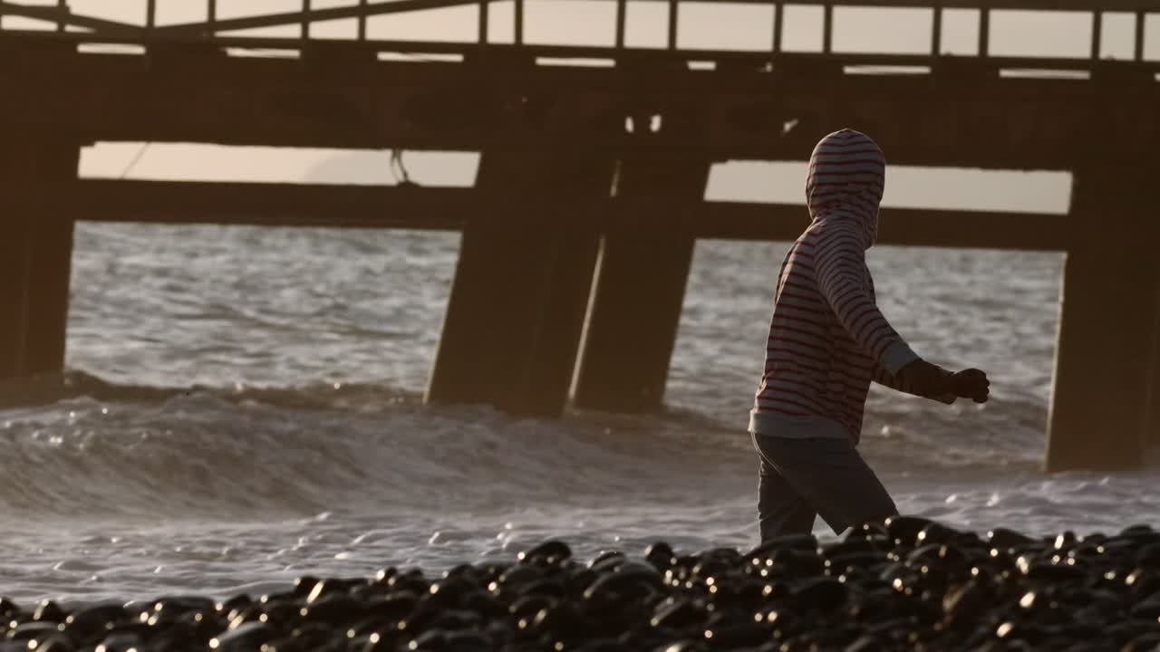 해가 지는 해변에서 산책하는 아이