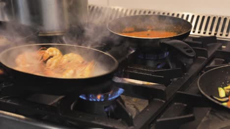 cook cooking shrimps in the kitchen in a frying pan with smoke and flames explosion