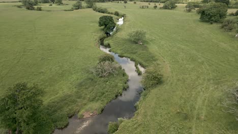 an aerial view of the tiny river arrow as it twists it's way through the warwickshire countryside, england