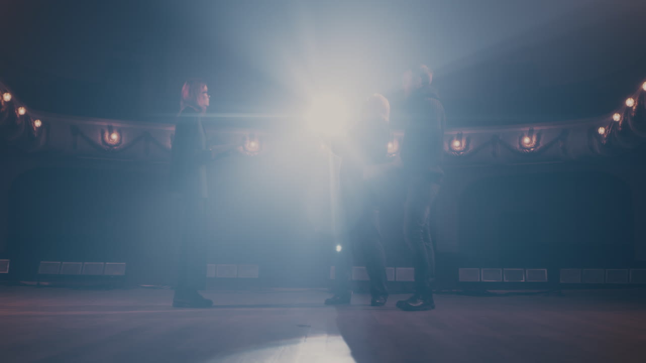 Director Giving Instructions to Actors during the Rehearsal of the Performance on the Stage with a Spotlight Director Giving Instructions on the Script to the Actors of the Theater and Talking