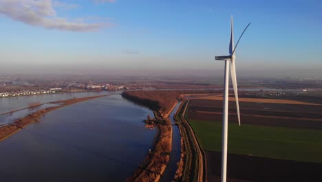 aerial view of giant wind turbine next to oude maas in netherlands