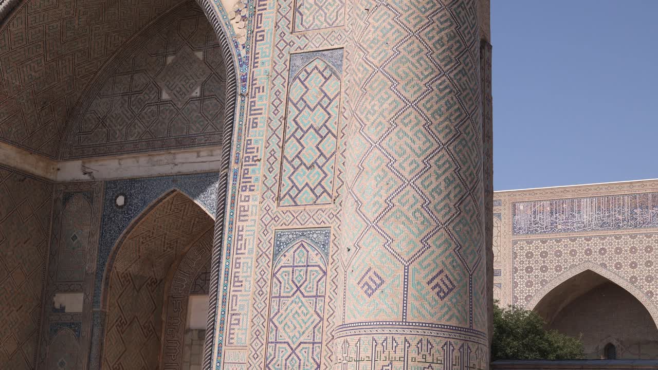 mirando hacia arriba el minarete detallado y la mezquita en la plaza registan en samarcanda, uzbekistán a lo largo de la histórica ruta de la seda