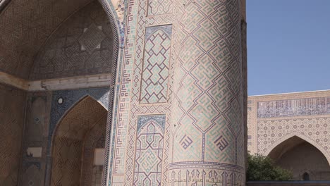 looking up at detailed minaret and mosque in registan square in samarkand, uzbekistan along the historic silk road