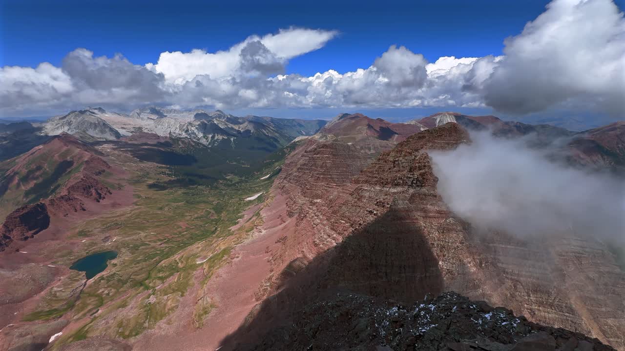 Capitol Peak Mount Snowmass Colorado summer panoramic view from North Maroon Peak Aspen Snowmmass Maroon Bells Wilderness fog snow sunny fourteener Elk Range Rocky Mountains rugged terrain pan left