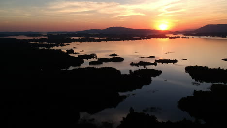 colourful sunset in orange red and blue on a sea in laos with small islands