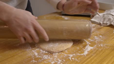 Dando-Forma-A-La-Masa-En-La-Mesa-De-Madera-De-La-Cocina