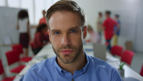 Portrait-confident-man-posing-camera-conference-room.-Guy-standing-modern-office