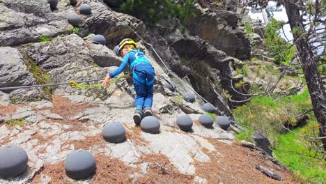 a child climbs the via ferrata in the alta badia, dolomites, italy - tracking shot