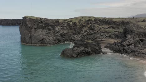 Luftfliegen-Rückwärts-Im-Wilden-Küstengebiet-Islands-Mit-Türkisfarbenem-Wasser