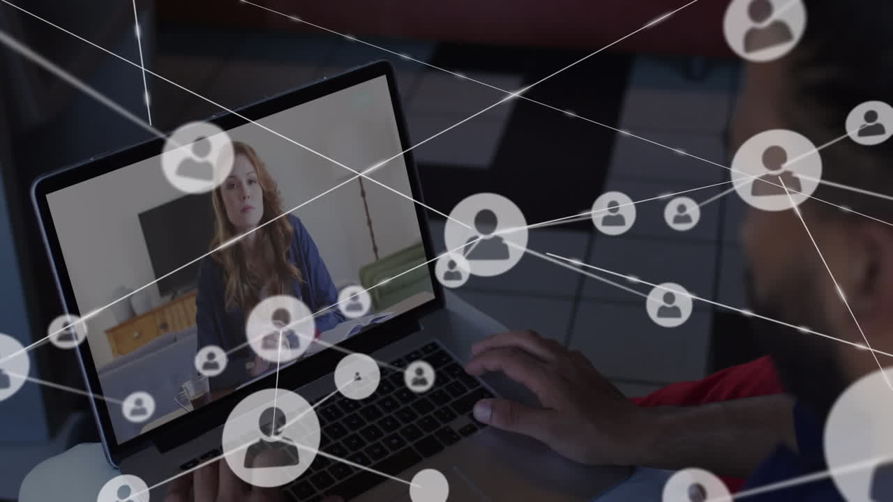 Animation of network of profile icons over rear view of biracial man having a video call on laptop